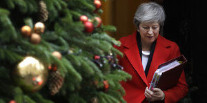 Theresa May neben einem geschmücken Tannenbaum