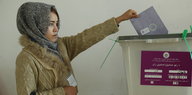 Eine Wählerin wirft ihren Stimmzettel für die Parlamentswahlen in eine Wahlurne
