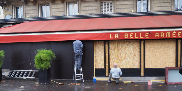 Frankreich, Paris: Arbeiter sichern die Terrasse des Lokals "La Belle Armée" mit Spanplatten