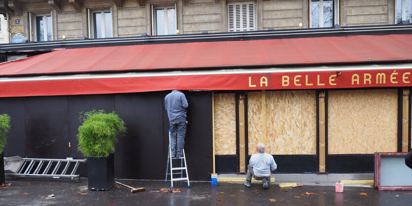 Frankreich, Paris: Arbeiter sichern die Terrasse des Lokals "La Belle Armée" mit Spanplatten