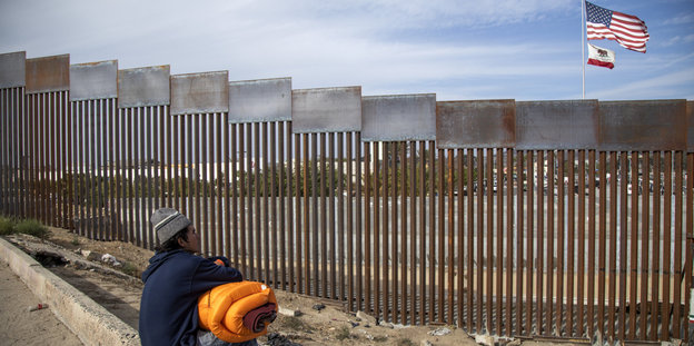 Ein Migrant auf der mexikanischen Seite der Grenze schaut in Richtung USA