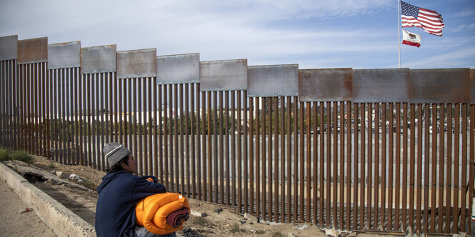 Ein Migrant auf der mexikanischen Seite der Grenze schaut in Richtung USA