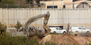 In Israel ist ein Bagger an einer Mauer