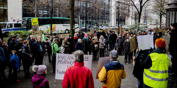 Menschen mit Protestschildern stehen gegenüber des Willy-Brandt-Hauses