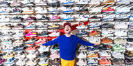 Janiv Koll steht vor seiner Sneakersammlung, aufgestellt über eine ganze Zimmerwand