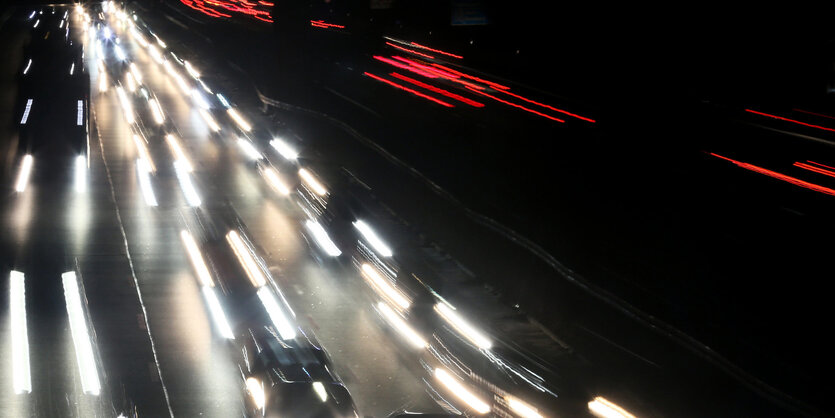 Lichter im Dunkeln. Es sind die Fahrzeuglichter von sich bewegenden Autos im Dunkel.