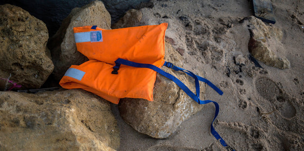 Eine Rettungsweste liegt auf Steinen am Strand