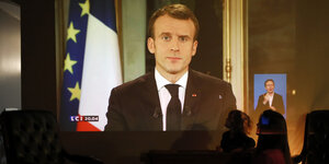Ein Mann an der Leinwand. Es ist Frankreichs Präsident Emmanuel Macron