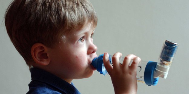 Ein Kind atmet durch ein Asthma-Gerät