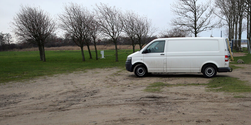 ein weißer Transporter auf einer Brache