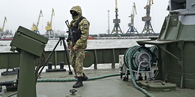 Ein ukrainischer Offizier auf einem Küstenwachschiff , er hält eine Waffe