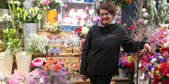 Eine Frau steht in einem Blumenladen