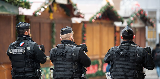 Polizist einer Spezialeinheit mit Maschinengewehr sichert den Tatort in Straßburg