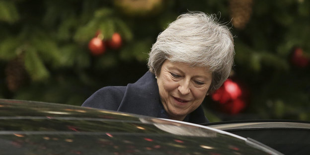 Eine Frau steht vor einem Tannenbaum. Es ist die britische Premierministerin Theresa May
