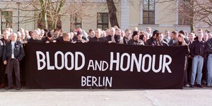 Rechtsradikale versammeln sich hinter einem Transparent von "Blood & Honour"