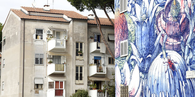 Zwei Häuser in Rom, eines ist mit buntem Graffito bemalt