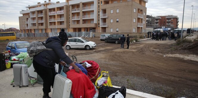 Eine Familie in Winterkleidung steht in einer brachen Gegend