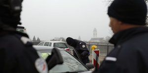 Französische Polizisten kontrollieren ein Auto