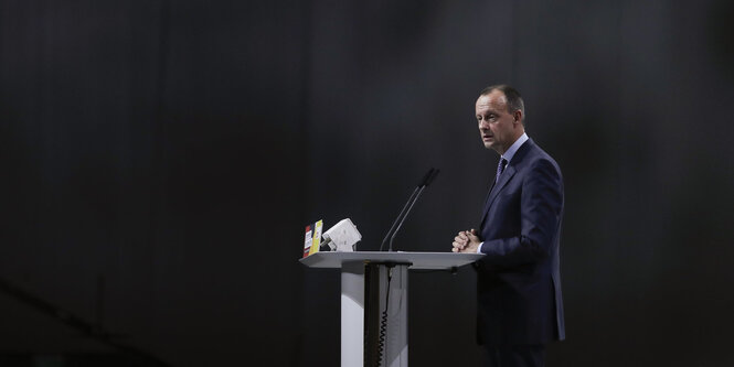 Friedrich Merz steht an einem Pult mit Mikrophon