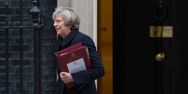 Theresa May, eine Frau mit Akten im Arm geht aus einem Haus