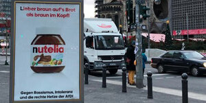 Plakat auf Berliner Straße, darauf abgebildet ein Nutellaglas vor weißem Grund, darüber der Slogan "Lieber braun auf's Brot als braun im Kopf!"