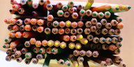 Verschiedenfarbige Buntstifte stehen in einer Kita auf einem Tisch