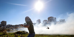 Vermummter Palästinenser schwingt eine Steinschleuder