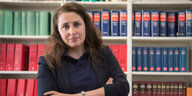 Die Rechtsanwältin Seda Başay-Yıldız steht vor einer Schrankwand mit juristischer Literatur