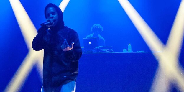 Rapper Earl Sweatshirt mit Mikrofon auf einer Bühne