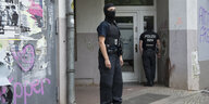 Vermummte Polizistin vor Gebäude in Neukölln