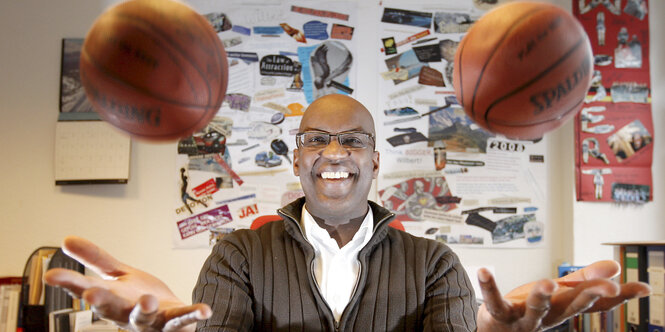 Der ehemalige Basketball-Bundesligaspieler Wilbert Olinde jongliert 2008 in seinem Büro in Hamburg am Schreibtisch mit zwei Basketbällen