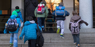 Kinder laufen Treppenstufen hinauf