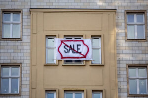 Ein Plakat mit Aufschrift Sale durchgestrichen hängt vor einem Fenster Ein Plakat mit Aufschrift Sale durchgestrichen hängt vor einem Fenster