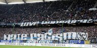 Eine Stadiontribüne voller HSV-Fans, die große Plakate gespannt haben, auf denen steht: Hate Racism