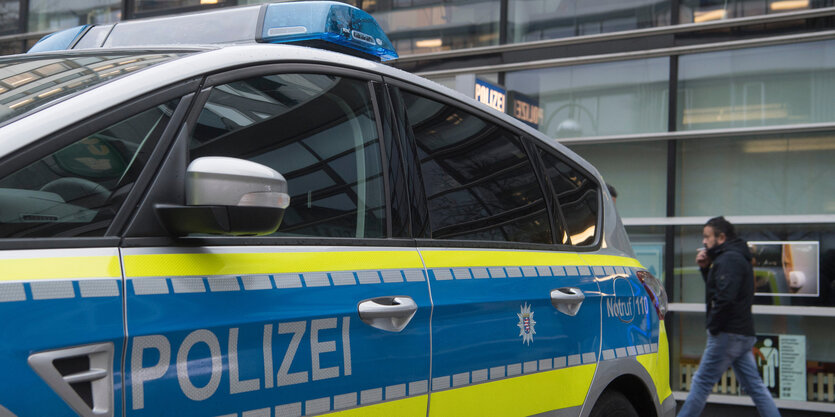 Ein Polizeiauto vor einem Gebäude, in dem ein Polizeirevier ist