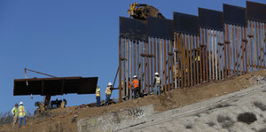 US-mexikanische Grenze: Bauarbeiter errichten eine Mauer