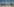 Eine Frau steht im Sand vor einer Skyline