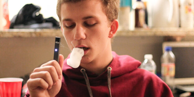Jugendlicher raucht eine E-Zigarette der Marke Juul