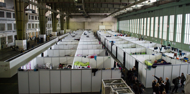 Im ehemaligen Flughafen Tempelhof stehen Doppelstockbetten in einem Hangar