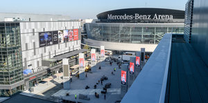 Das Bild zeigt die Mercedes Benz Arena hinter dem neuen Mercedes Platz in Berlin-Friedrichshain, graue Gebäude aus Glas und Beton.