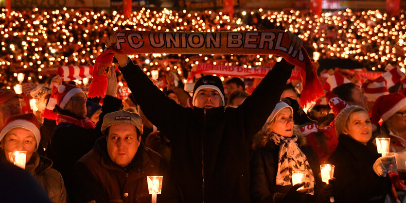 Menschen stehen im Stadion von Union und singen