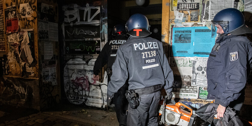 Zwei Polizisten in voller Montour vor einem hausprojekt in der Rigaer Straße