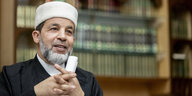 Mohamed Taha Sabri ist der Imam der Moschee des Vereins Neuköllner Begegnungsstätte - vor einem Regal mit Büchern zu sehen