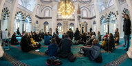 Im Innern der Şehitlik-Moschee in Berlin sitzen Gäste am Tag der offenen Moschee