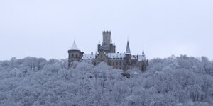Das Schloss Marienburg in einem weiß verschneiten Wald.