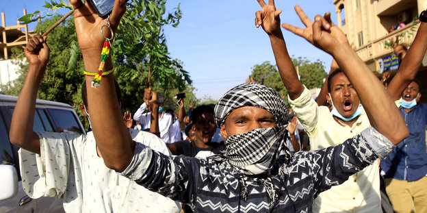 Demonstranten in Khartum rufen und gestikulieren