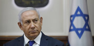 Benjamin Netanjahu, neben ihm eine israelische Flagge
