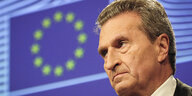 Günther Oettinger vor einer Flagge der Europäischen Union