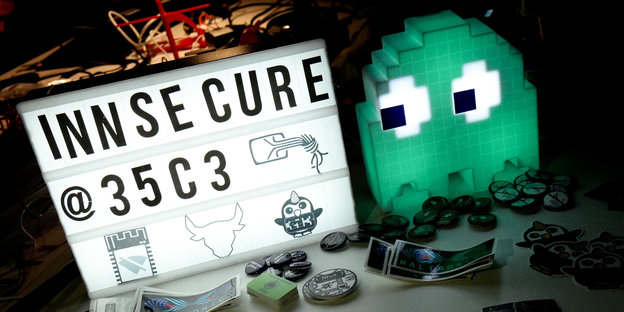 Ein Modell einer Videospielfigur schaut auf eine Anzeige auf dem "Innsecure 35c3" steht