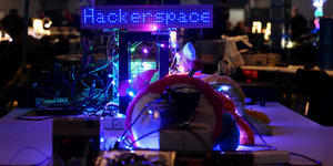 Auf einem Tisch sind bunte Lichter arrangiert, einige leuchten mit der Aufschrift Hackerspace